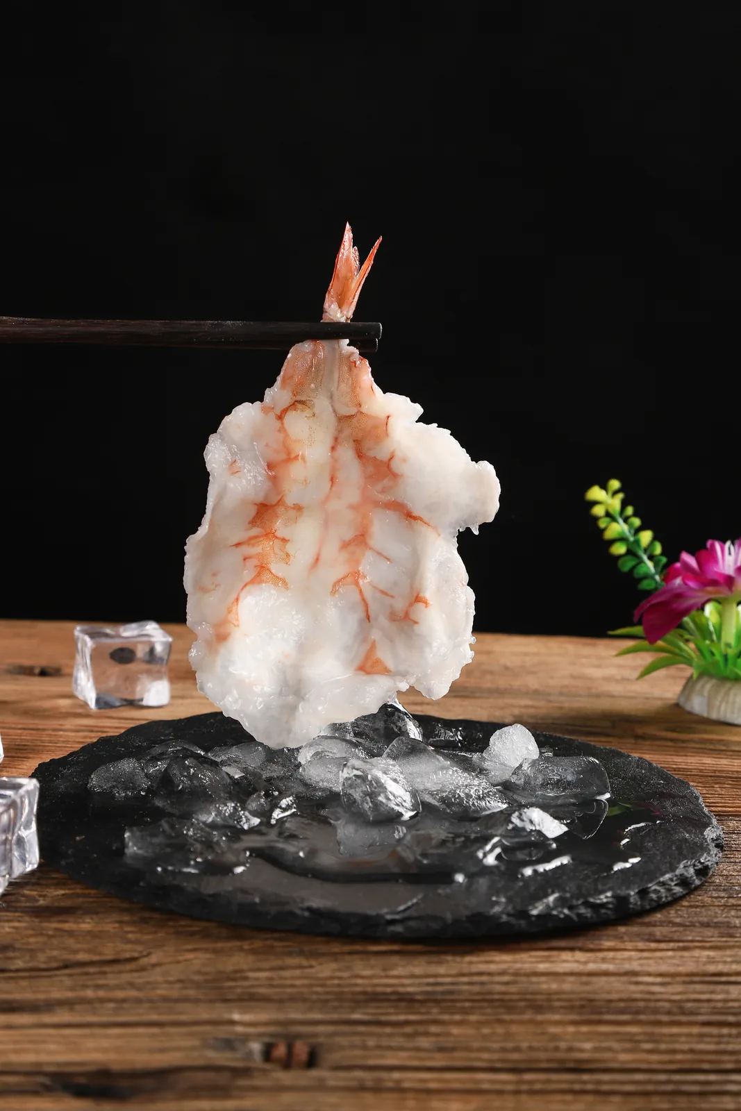 手工敲虾涮烫后，虾身转白，透出橙红色虾肉纹理，虾尾转红